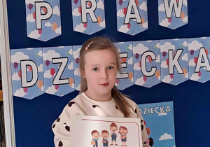 Dziewczynka wypowiada się na temat ilustracji trzymanej w rączkach