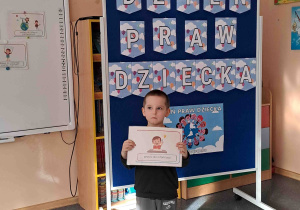 Chłopiec wypowiada się na temat ilustracji trzymanej w rączkach