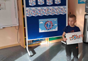 Chłopiec wypowiada się na temat ilustracji trzymanej w rączkach