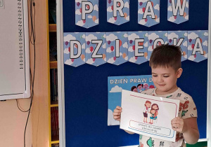 Chłopiec wypowiada się na temat ilustracji trzymanej w rączkach