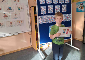 Chłopiec wypowiada się na temat ilustracji trzymanej w rączkach