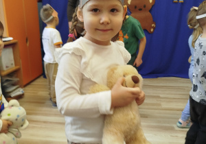 Dziewczynka trzyma w ręku pluszowego misia