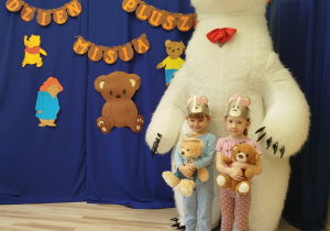 Dziewczynki stoją przed białym misiem