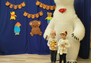 Chłopcy pozują do zdjęcia z białym misiem