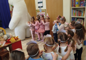 Dzieci ustawiają się za białym misiem