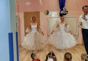 Panie prezentują dzieciom suknie