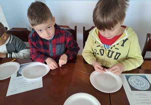 Dzieci projektują wzory na papierowych talerzykach