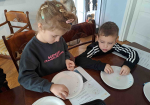 Dzieci projektują wzory na papierowych talerzykach