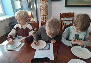 Dzieci projektują wzory na papierowych talerzykach