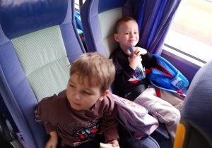 Chłopcy jedzą i piją podczas podróży