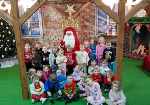 Dzieci pozują do wspólnego zdjęcia ze św. Mikołajem