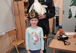 Dziecko w czapce czako pozuje wspólnie z górnikiem do zdjęcia.