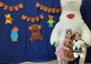 Dziewczynki wraz z białym misiem pozują do zdjęcia