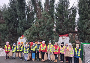 Dzieci pozują do zdjęcia przy świątecznych ozdobach.