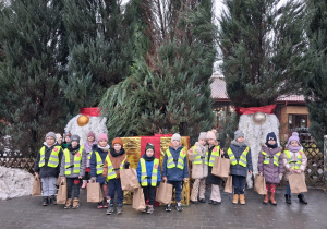 Dzieci pozują do zdjęcia przy świątecznych ozdobach.