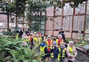 Dzieci pozują do zdjęcia w ogrodzie botanicznym.