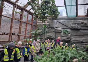 Dzieci pozują do zdjęcia w ogrodzie botanicznym.