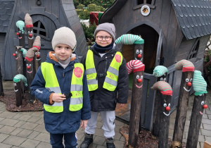 Dwóch chłopców pozuje do zdjęcia przy ozdobach świątecznych.