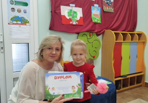 Dziewczynka pozuje do zdjęcia z Dyrekcją