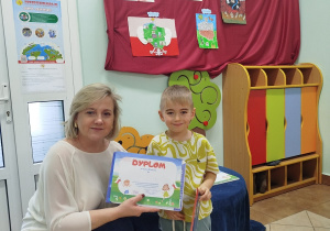 Chłopiec pozuje do zdjęcia z Dyrekcją