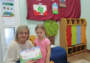 Dziewczynka pozuje do zdjęcia z Dyrekcją