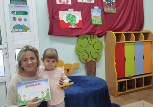 Dziewczynka pozuje do zdjęcia z Dyrekcją