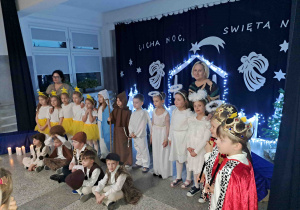 Grupa występujących dzieci na tle dekoracji