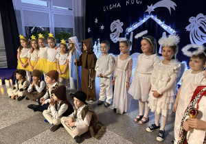 Grupa występujących dzieci na tle dekoracji