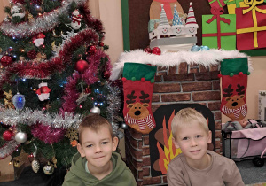 Pamiątkowe fotografie dzieci przed choinką i kominkiem