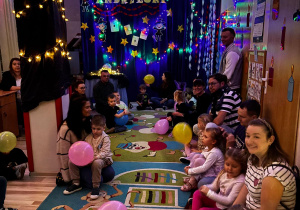 Dzieci siedzą z rodzicami na dywanie