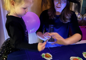 Pani wróży dziewczynce za pomocą latarki i obrazka