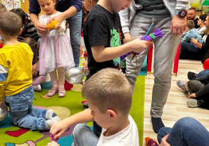 Dzieci odwijają papierki cukierków