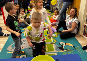 Chłopiec wrzuca monetę do miski z wodą