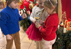 Dziewczynki trzymają słoik z pieniążkami