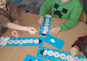 Tworzymy śnieg stemplując patyczkami kosmetycznymi i białą farbą