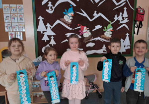 Dzieci prezentują portrety wykonanych bałwanków