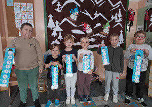 Dzieci prezentują portrety wykonanych bałwanków