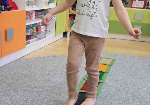 Dzieci boso spacerują po ścieżce sensorycznej