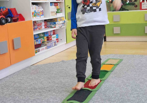 Dzieci boso spacerują po ścieżce sensorycznej