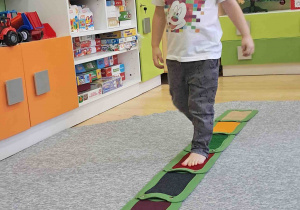 Dzieci boso spacerują po ścieżce sensorycznej