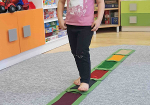 Dzieci boso spacerują po ścieżce sensorycznej