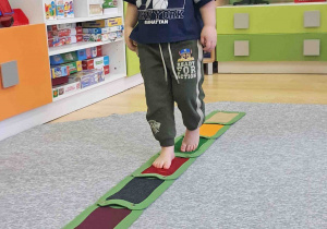 Dzieci boso spacerują po ścieżce sensorycznej