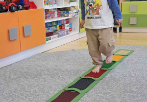 Dzieci boso spacerują po ścieżce sensorycznej