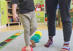 Dzieci boso spacerują po ścieżce sensorycznej