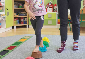 Dzieci boso spacerują po ścieżce sensorycznej