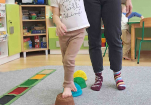 Dzieci boso spacerują po ścieżce sensorycznej