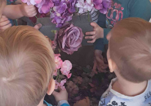 Dzieci oglądają sztuczne kwiaty przyniesione przez florystkę