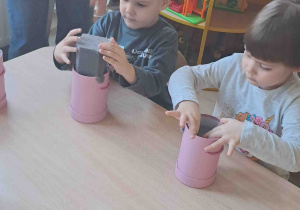 Przedszkolaki wkładają gąbkę do pudełek