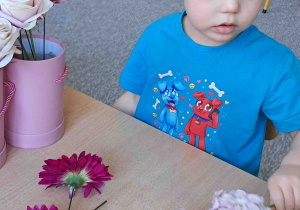 Dzieci samodzielnie tworzą kompozycje ze sztucznych kwiatów