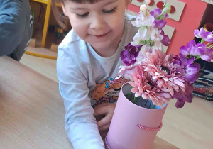 Dzieci samodzielnie tworzą kompozycje ze sztucznych kwiatów